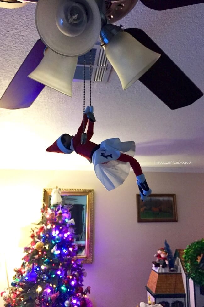 Elf on the Shelf hanging from a ceiling fan