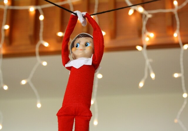 Elf zip-lining on Christmas lights