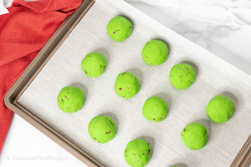 balls of green cookie dough on baking sheet