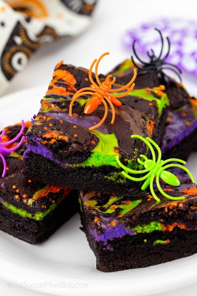 stack of colorful Halloween brownies with orange, green, and purple cheesecake swirl.