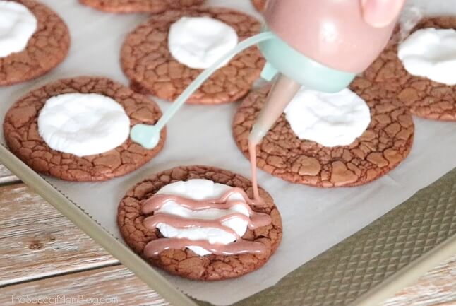 drizzling chocolate icing on hot cocoa cookies