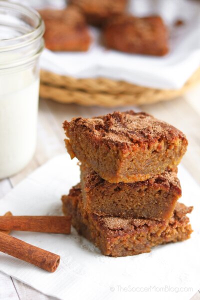 stack of chickpea blondies, cinnamon sticks, glass of milk