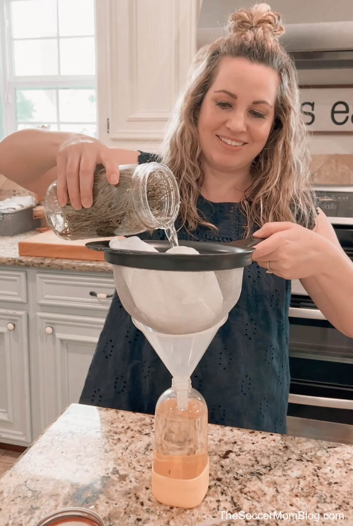 pouring homemade pine sol through a strainer into a spray bottle